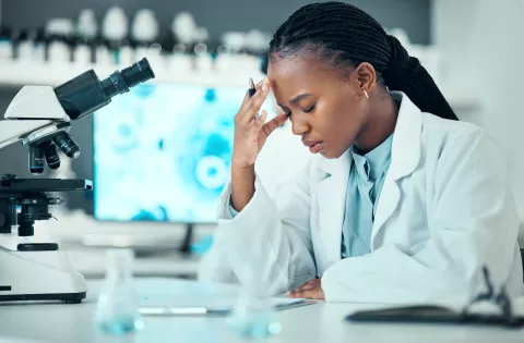 Professor with head in hand, microscope